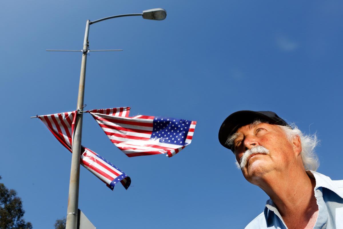 Robert Rosebrock, Director of the Old Veterans Guard, stands next to American flags hanging in disarray on Wilshire Blvd, near the VA Medical Center in Brentwood on April 29, 2013.