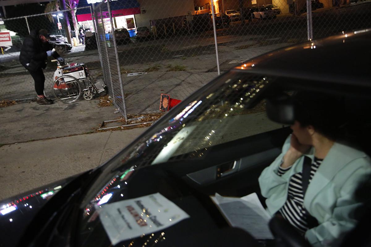 A person in a car looks out the window at a homeless person as they help with Brentwood's first-ever homeless count.