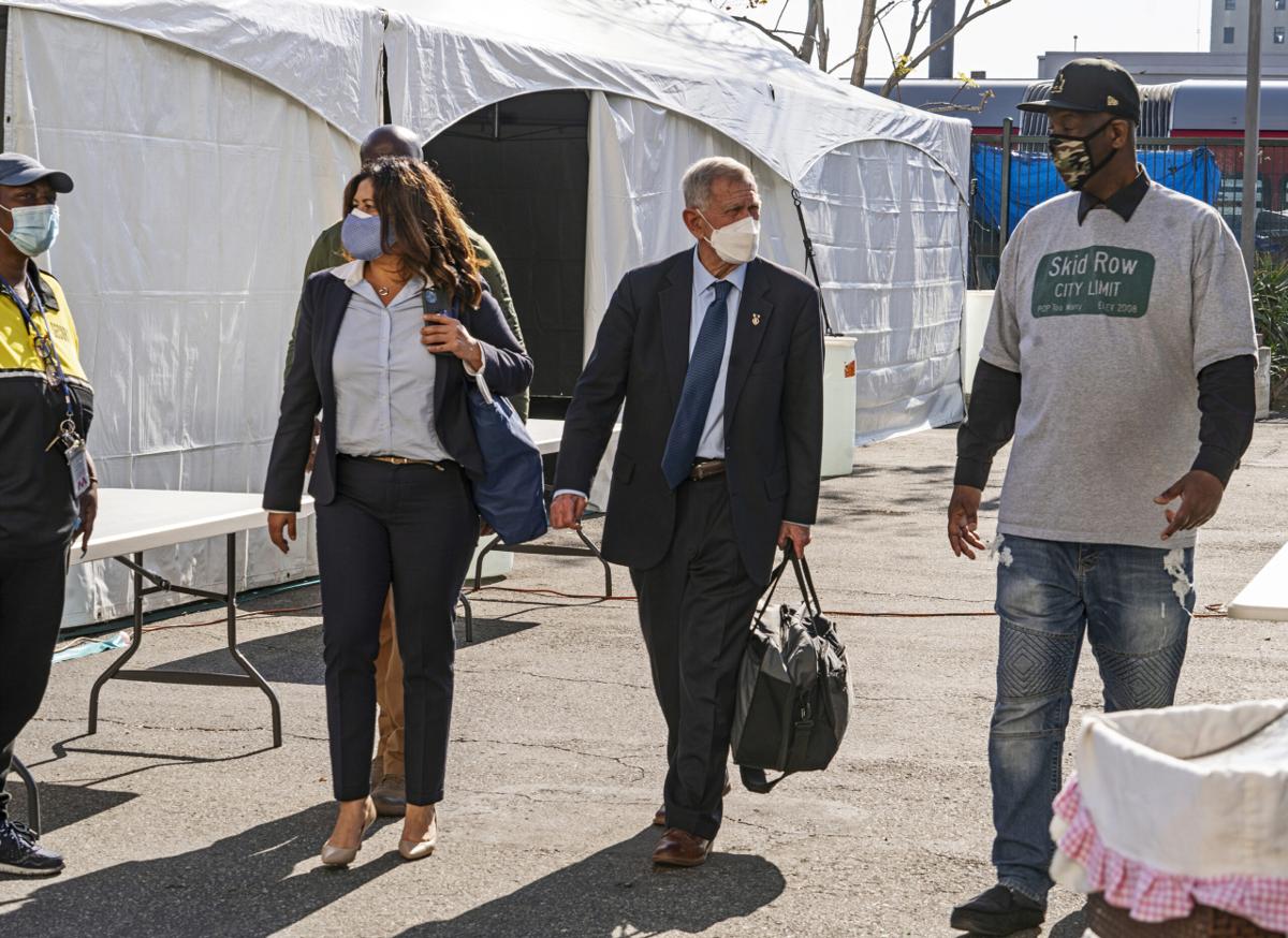 Jeff Page, right, also known as General Jeff, a homelessness activist, walks with U.S. District Court Judge David Carter, middle, and Michele Martinez, special master on the issues of homelessness, after a court hearing in Los Angeles.